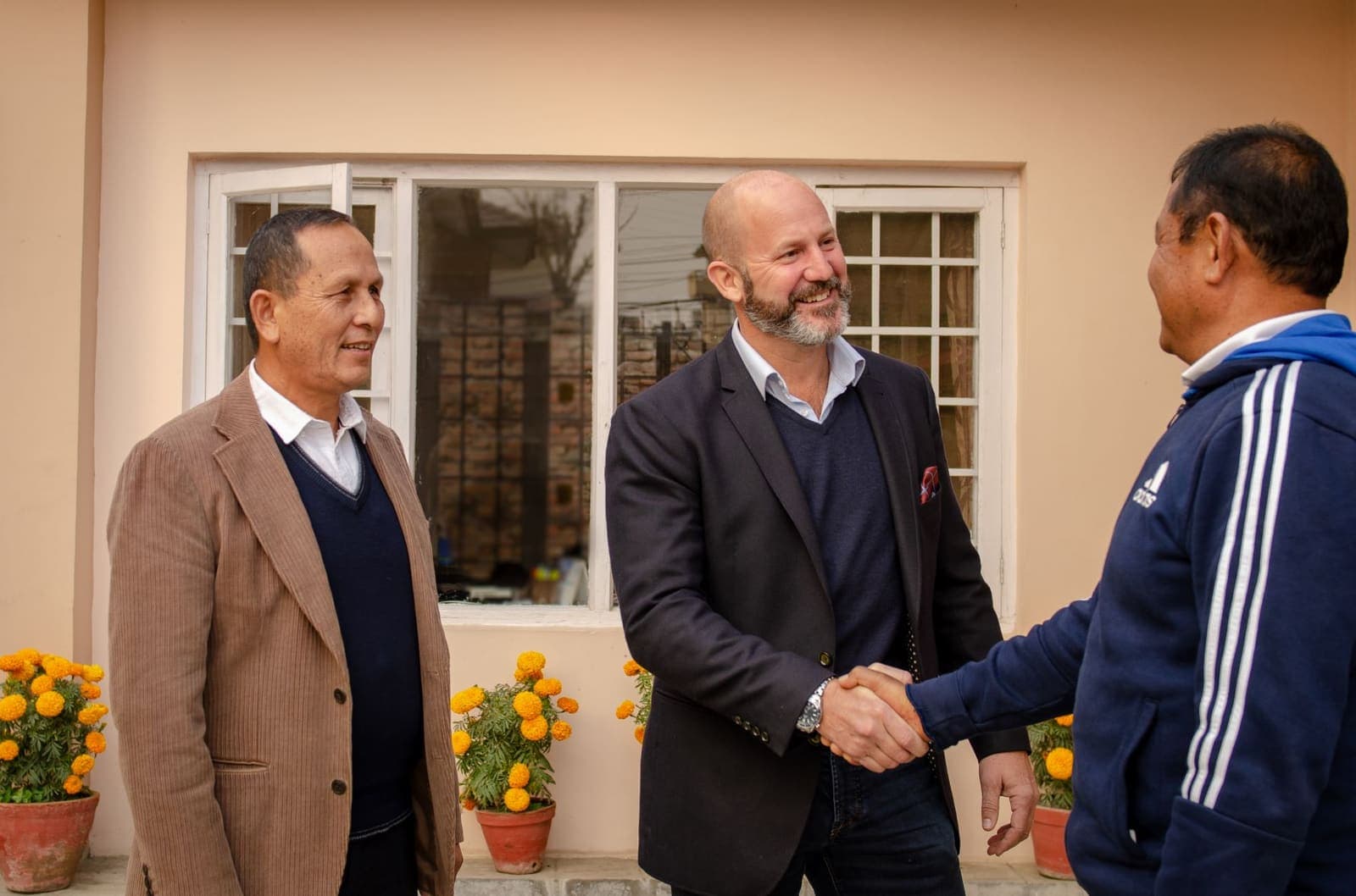 FSI team members greeting a colleague outside the Nepal office