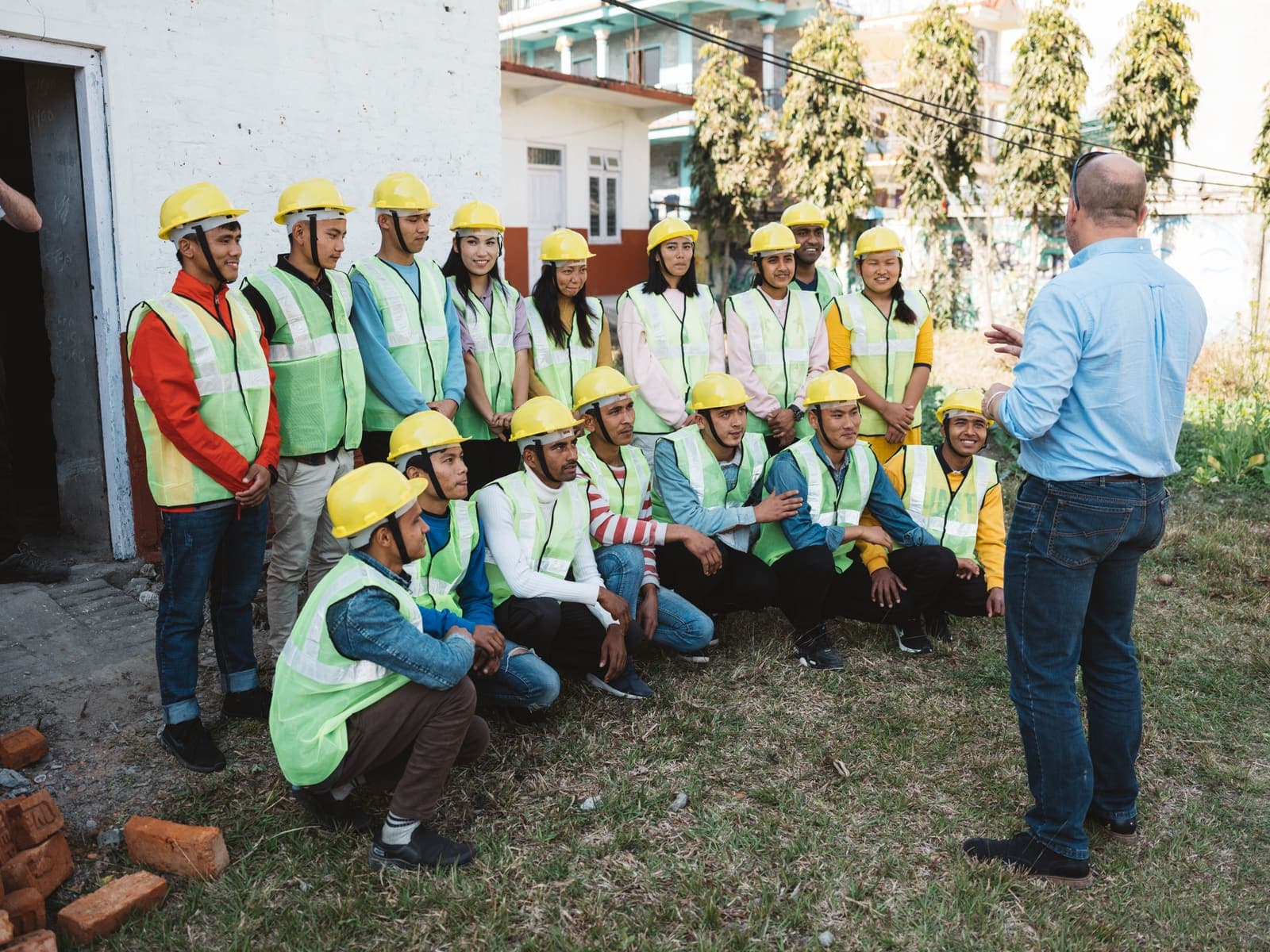 Construction cohort in safety gear at a pre-deployment briefing in Pokhara